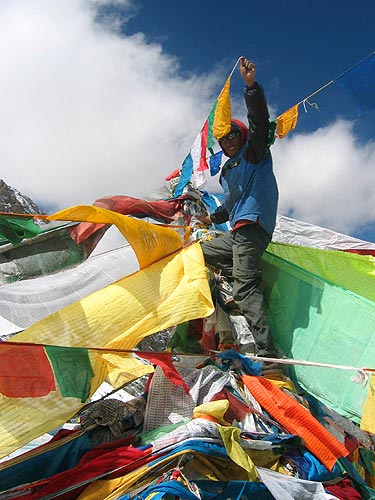 Setting prayer-flags on the Doelma Lathe pass, the highest point of the kora, altitude 5600 m, in the name of \'Yoga in Daily Life\'