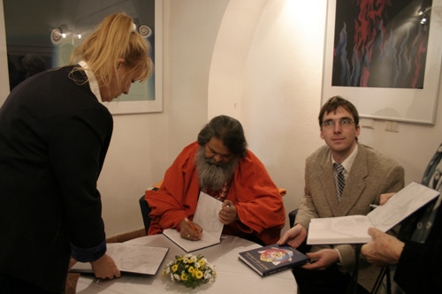 Swamiji autographs first copies of the book