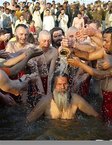 Indian spiritual leader His Holiness Mahamandaleshwar Paramhans Swami Maheshwaranandji takes a holy dip along with his western devotees at the confluence of the rivers Ganges, Yamuna and mythical Saraswati on the Makar Sankranti festival, an auspicious day during the 45-day long Ardh Kumbh Mela festival, in Allahabad, India, Sunday, Jan. 14. ((c) Associated Press)